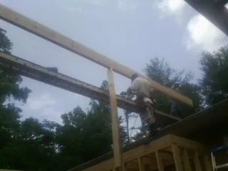 Carpenter setting a ridge beam over a new addition frame — Ice Dam Removal by Roofing Brothers in San Martin