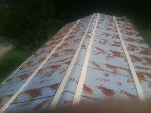 Rusted metal roof panels with new wood purlins before replacement — Storm Damage Roof Repair in San Martin by Roofing Brothers