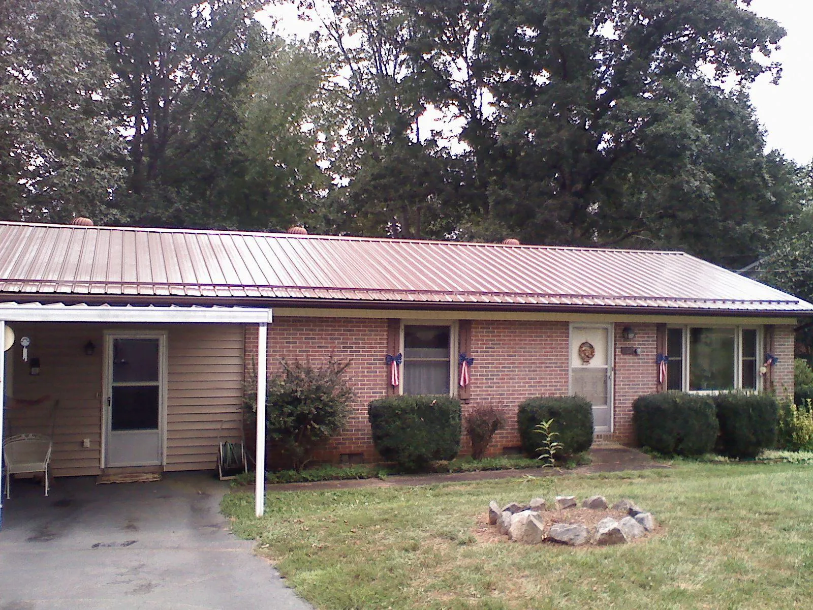 Bronze metal roof and carport on a brick ranch home — Roof Repair work by our crew in San Martin