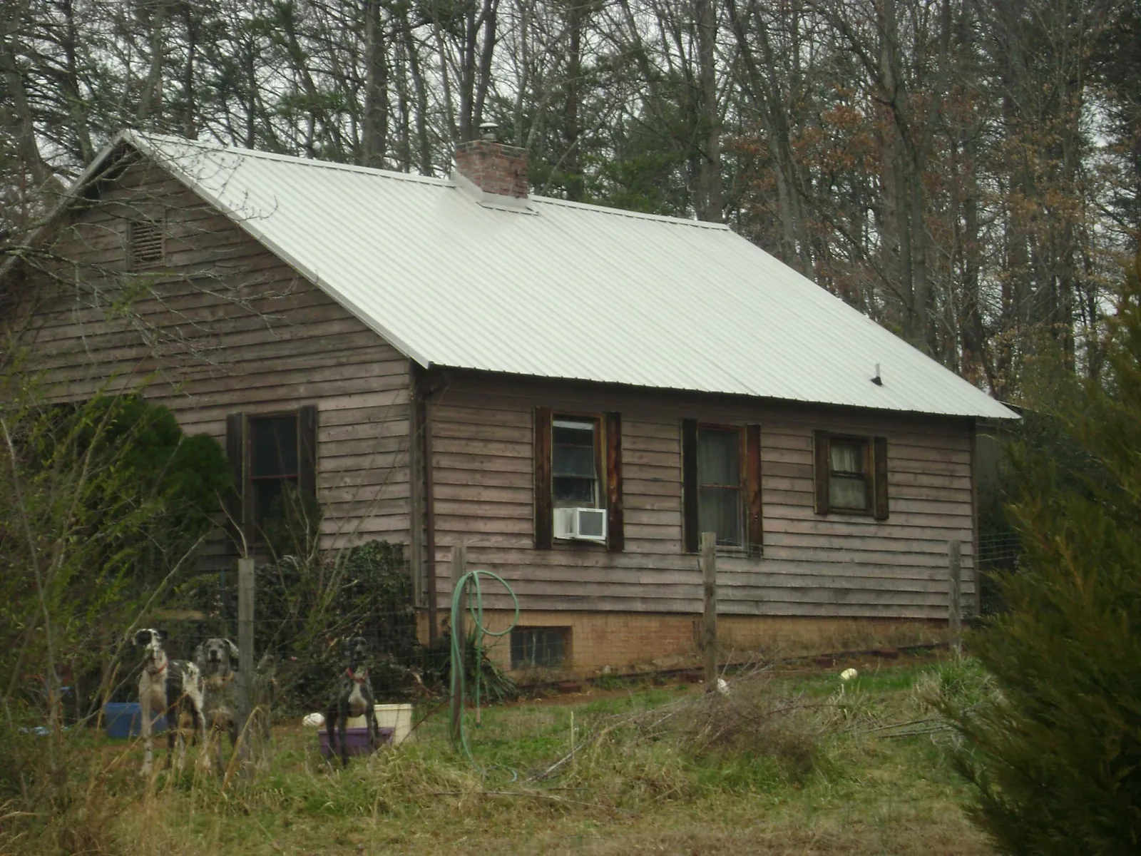 White metal roof on an old wood sided farmhouse, from a Metal Roof Installation job in San Martin